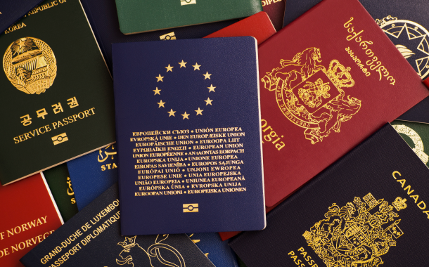 A stack of passports from multiple countries in red, blue, green, and dark green, symbolizing residency and citizenship opportunities worldwide.